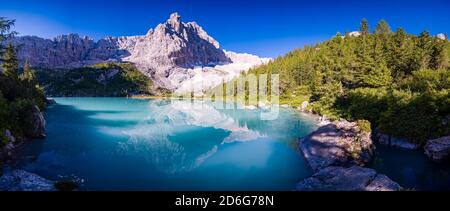 Vista panoramica sul lago turchese Lago di Sorapiss, la cima della montagna Punta Nera in lontananza, all'alba. Foto Stock