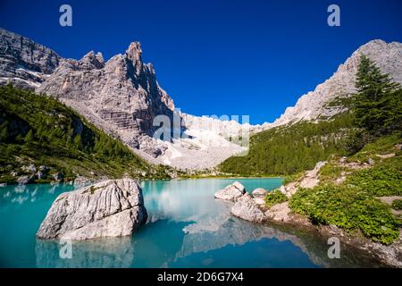 Vista panoramica sul lago turchese Lago di Sorapiss, la cima della montagna Punta Nera in lontananza, all'alba. Foto Stock