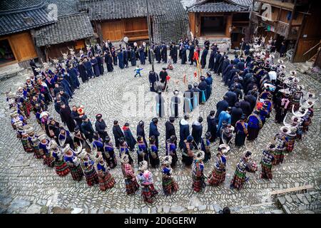 Giovani e vecchi che eseguono una danza tradizionale circolare. Sono della lunga gonna lunga del popolo Miao. Area di Kaili, provincia di Guizhou, Cina Foto Stock