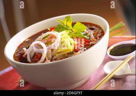 Asam Laksa, una saporita, piccante e piccante zuppa di pasta di riso a base di pesce malese Foto Stock