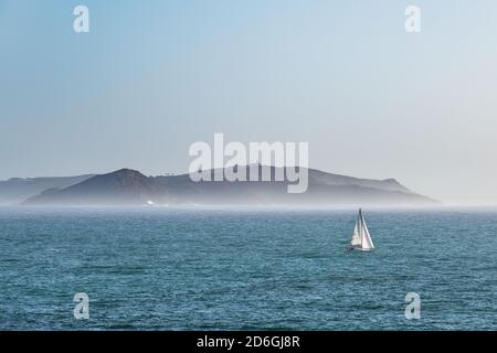 Una barca solitaria parte dall'isola di Ons nella Ria de Pontevedra in Galizia al tramonto. Foto Stock