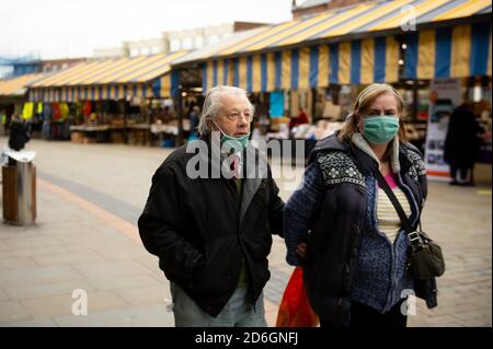 Gli acquirenti che indossano maschere facciali protettive camminano nel Market Place, Dudley, nelle West Midlands. Dudley può unirsi ad altre parti del Black Country e Birmingham nel livello 2 delle restrizioni del coronavirus. Foto Stock