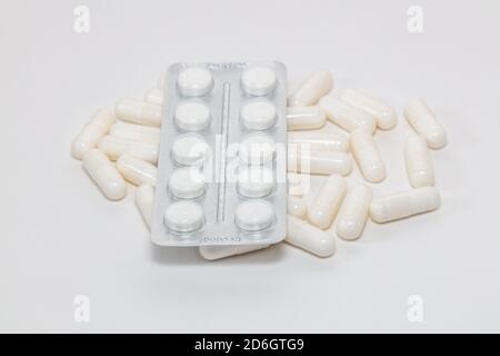 Immagine ad alto angolo di varie pillole bianche su sfondo bianco. Alcuni di loro sono fuori fuoco. Business farmaceutico e vendita di farmaci concetti. Foto Stock