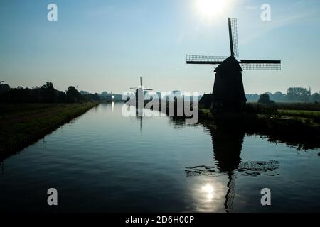 La vista dalla campagna olandese presso la città di Alkmaar nei Paesi Bassi. Il canale con i mulini a vento vicino alla città. Foto Stock