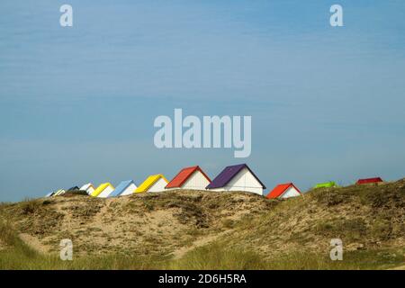 Le piccole case bianche spiaggia con tetti colorati su una spiaggia di Gouville-sur-Mer in Francia in Normandia. L'attrazione per i turisti. Foto Stock