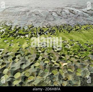 Balangan Beach con rocce erose e muschio verde a Bali, Indonesia Foto Stock