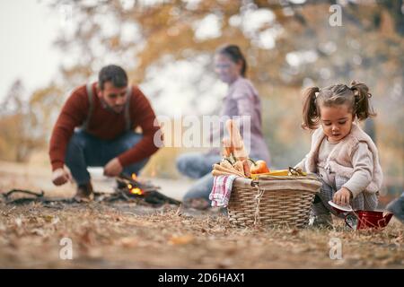 Felice famiglia che ha un picnic insieme nella foresta sopra una bella giornata d'autunno Foto Stock