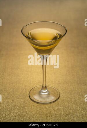 Cocktail alla vodka Martini con tocco di limone al chiuso su tessuto dorato Foto Stock