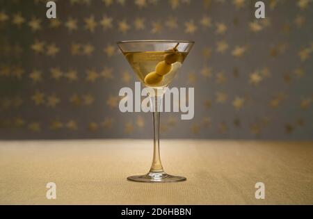 Cocktail alla vodka martini con tre olive su tessuto dorato con sfondo stellato Foto Stock