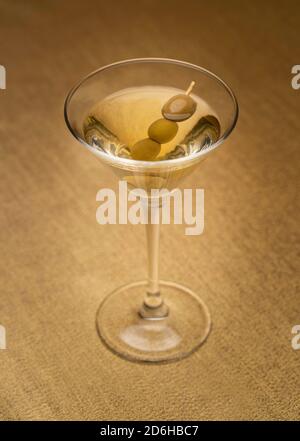 vodka martini con olive interne su tessuto dorato Foto Stock