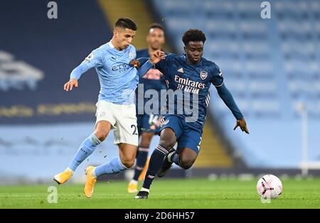 Joao Cancelo di Manchester City (a sinistra) e l'Arsenal's Bukayo Saka combattono per la palla durante la partita della Premier League all'Etihad Stadium di Manchester. Foto Stock