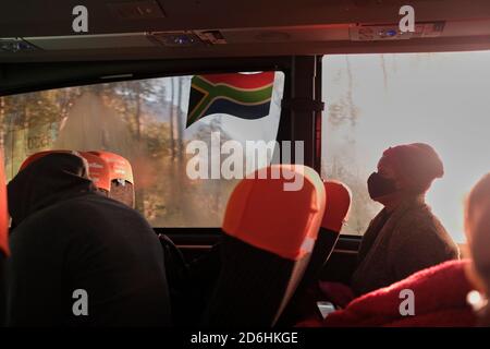 I passeggeri che indossano maschere durante il viaggio su un autobus (pullman) in Sud Africa durante il periodo pandemico di Covid-19. Foto Stock