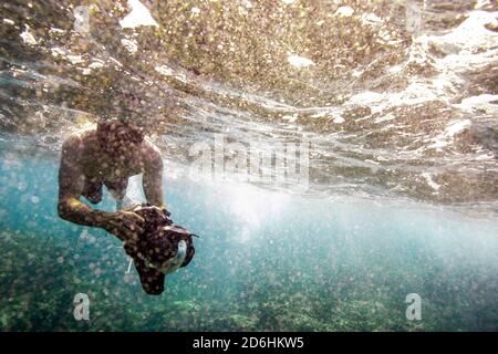 Fotografo subacqueo galleggia sulla superficie dell'oceano in Oahu Foto Stock