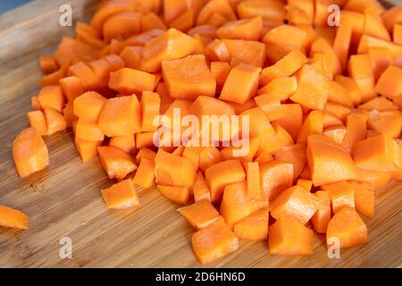 Carote a dadini su tagliere di legno, cibo Foto Stock