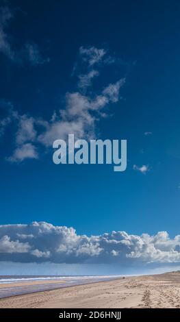 Grande cielo blu e vicino alla spiaggia vuota di Anderson Creek, Lincolnshire, in una giornata di sole autunno. Foto Stock