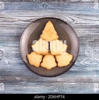 Piatto con biscotti a forma di albero di Natale su fondo di legno. Foto Stock