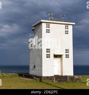 Faro bianco a Capo Bjargtangar, Latrabjarg, Penisola di Vestfiroir, Westfjords, Islanda Foto Stock