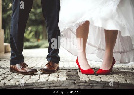 Gambe di sposa e di sposo piegate verso l'interno. Divertente e concettuale Foto Stock