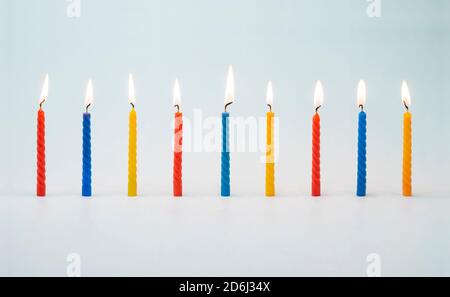 Candele colorate illuminate per torte di compleanno Foto Stock