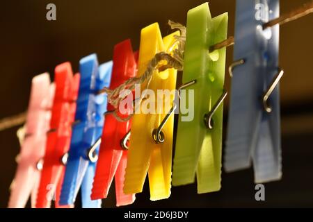 I picchetti colorati di vestiti. Spille appendenti su una corda della linea di vestiti Foto Stock