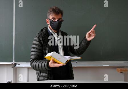 Insegnante con giacca invernale spessa, sciarpa e maschera facciale nell'insegnamento in classe, Corona Crisis, Stoccarda, Baden-Wuerttemberg, Germania Foto Stock