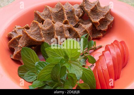 Polpette crude turche (CIG kofte), piccante turco meatless con pomodoro e concetto di cibo alla menta Foto Stock