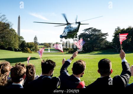 Washington, Stati Uniti d'America. 14 ottobre 2020. Gli stagisti della Casa Bianca che sventolano bandiere americane sono visti come Marine One che porta il presidente Donald J. Trump si solleva dal prato sud della Casa Bianca Mercoledì, 14 ottobre 2020, sulla strada per la base congiunta Andrews, M. per iniziare il suo viaggio a Des Moines, Iowa. Persone: Presidente Donald Trump Credit: Storms Media Group/Alamy Live News Foto Stock