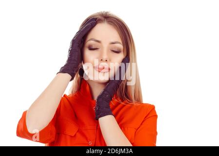 Donna occhi chiusi in guanti neri che toccano la faccia mostrando trattamento anti-età che ha ricevuto, aumento labbro anti-rughe colpi isolati su bianco. Beau Foto Stock