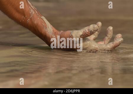 Primo piano della mano di un uomo sulla sabbia Foto Stock