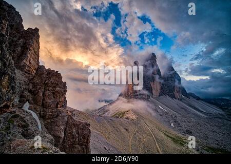 Vista panoramica sul gruppo montuoso tre Cime di Lavaredo, visto da Paternkofel Scharte, in parte coperto da nuvole al tramonto. Foto Stock