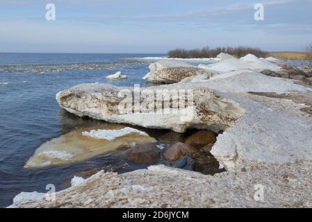 Gobbi di neve sulla riva del lago di Ladoga primavera. Regione di Leningrad, Russia Foto Stock