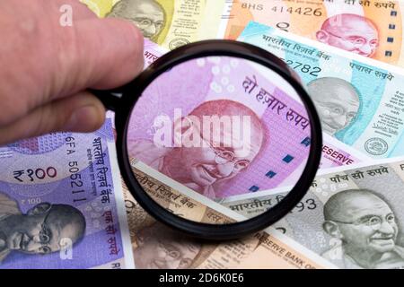Rupia indiana in una lente d'ingrandimento Foto Stock