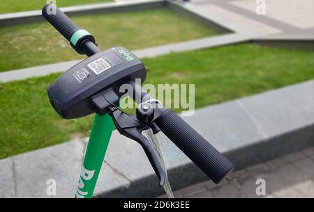 Primo piano del volante di uno scooter elettrico. City scooter elettrico della società Bolt in affitto in piedi fuori. Trasporto ecologico conce Foto Stock