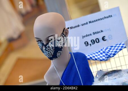 Monaco, Germania. 15 Ott 2020. Le maschere di design sono disponibili in una vetrina, mentre un manichino indossa una maschera facciale, maschera, bocca e protezione del naso. | utilizzo in tutto il mondo credito: dpa/Alamy Live News Foto Stock