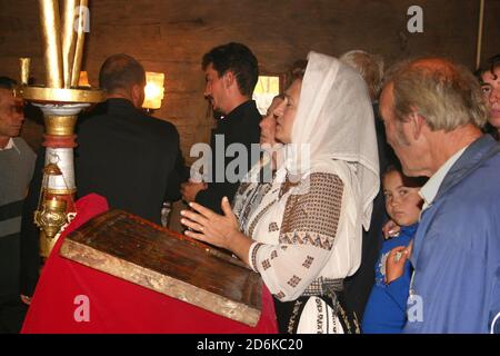 La chiesa cristiana ortodossa di legno del 18 ° secolo a Leleasca, Olt County, Romania. Parrocchiani che pregano durante il servizio religioso. Foto Stock