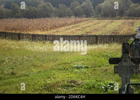 Terreno coltivato nei pressi di un cimitero di Oltenia, Romania Foto Stock