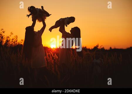 buone mamme che giocano all'aperto con i bambini in estate. Felice famiglia tempo insieme concetto. Fuoco selettivo. Foto Stock