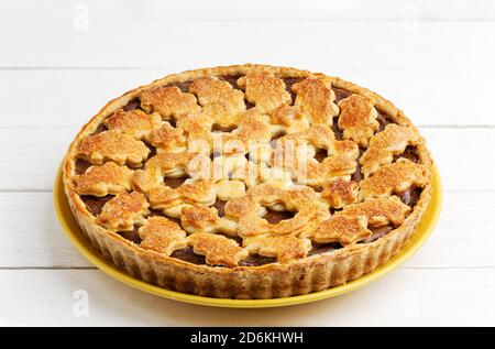 Torta fatta in casa con formaggio casolare e prugne su tavolo di legno bianco. Foto Stock