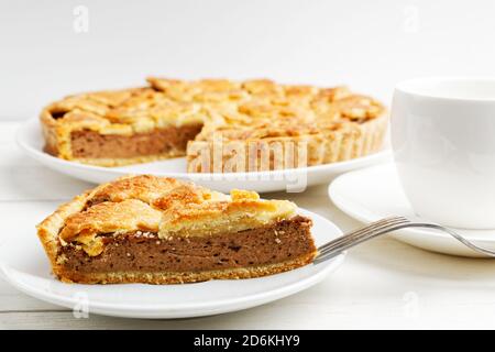 Primo piano di torta fatta in casa con formaggio cottage e prugne su sfondo sfocato. Messa a fuoco superficiale. Foto Stock