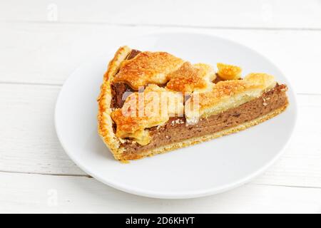 Primo piano di torta fatta in casa con formaggio casereccio e prugne su piastra bianca Foto Stock