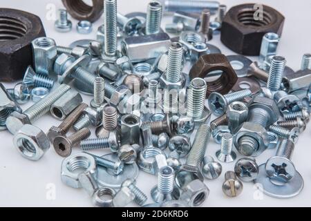 Chromeplated bulloni e dadi su sfondo bianco Foto Stock