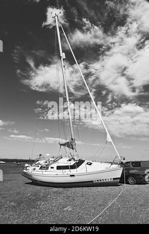 Yacht in barca a bassa marea a Brancaster Staith sulla costa di Norfolk, Regno Unito Foto Stock