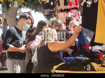 Las Palmas, Gran Canaria, Isole Canarie, Spagna. 18 ottobre 2020. Shopping in vigore presso il mercato domenicale all'aperto vicino alla spiaggia cittadina di Las Palmas su Gran Canaria. Con un'incombenza a metà termine e nessun segno di una corsa di Brit alle Isole Canarie, la mancanza di turisti alle isole durante la pandemia è un disastro per l'economia dipendente dal turismo. Pur essendo la regione spagnola con il minor numero di casi di Covid, le isole Canarie e il resto della Spagna rimangono nell'elenco di quarantena del Regno Unito. Credit: Alan Dawson/Alamy Live News. Foto Stock