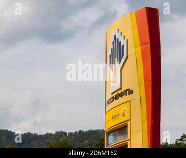 Altai, Russia - 08.17.2020: Un cartellone per una rete russa di stazioni di servizio Rosseft in giallo con cartelli benzina e un logo aziendale in estate Foto Stock