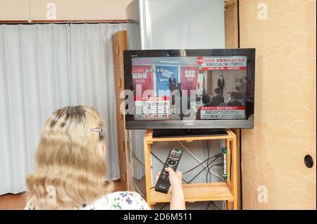 Fuji City, Shizuoka, Giappone - 14 settembre 2020: Woman guarda la conferenza stampa in diretta dalla televisione giapponese di Yoshihide Suga. Foto Stock