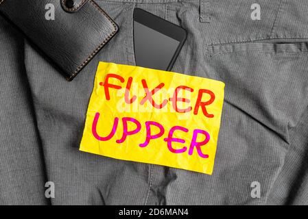 Nota di scrittura che mostra Fixer Upper. Concetto di business per la casa che ha bisogno di riparazioni utilizzato principalmente connessione con l'acquisto di smartphone dispositivo all'interno di pantaloni Foto Stock