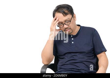 Uomo di mezza età seduto sulla sedia e sensazione di stress e mal di testa isolato su sfondo bianco. Problema e concetto di assistenza sanitaria. Foto Stock