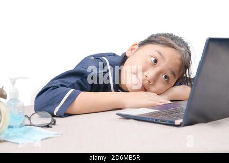 Felice ragazza cute che guarda i video in streaming online sul suo laptop a casa isolato su bianco. Homeschooling, apprendimento a distanza e nuovo concetto normale Foto Stock