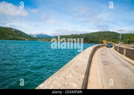 Auto che attraversa il serbatoio di Ruesga. Cervera de Pisuerga, provincia palencia, Castilla Leon, Spagna. Foto Stock