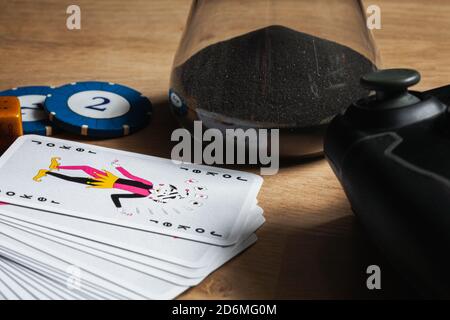 Giochi notte stare in con amici sfondo poker chip dadi & carte video giochi controller su tavolo di legno. Stare in amici attività gioco d'azzardo f Foto Stock